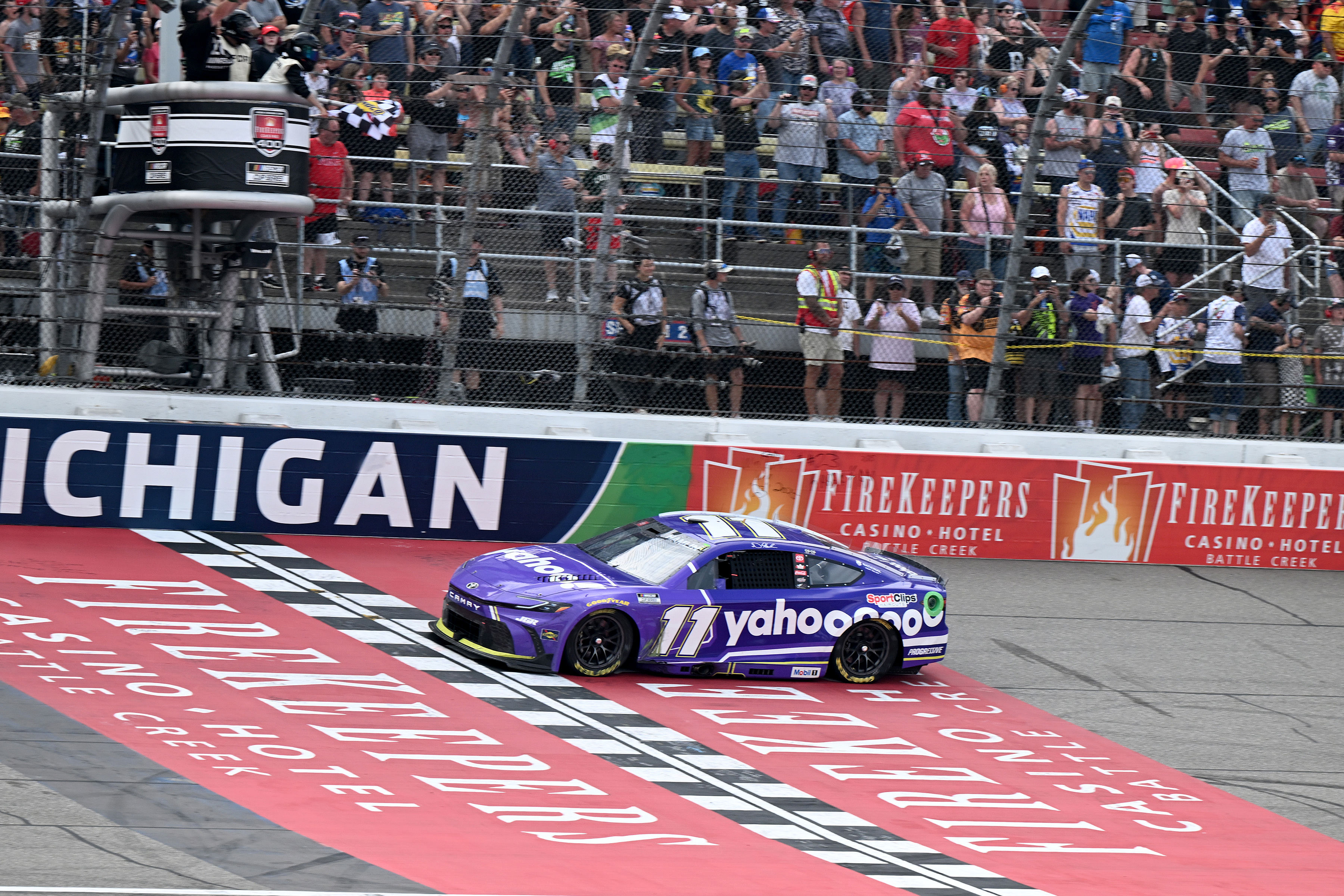 Denny Hamlin (11) crosses the finish line to win the FireKeepers Casino 400 at Michigan International Speedway. - Source: Imagn